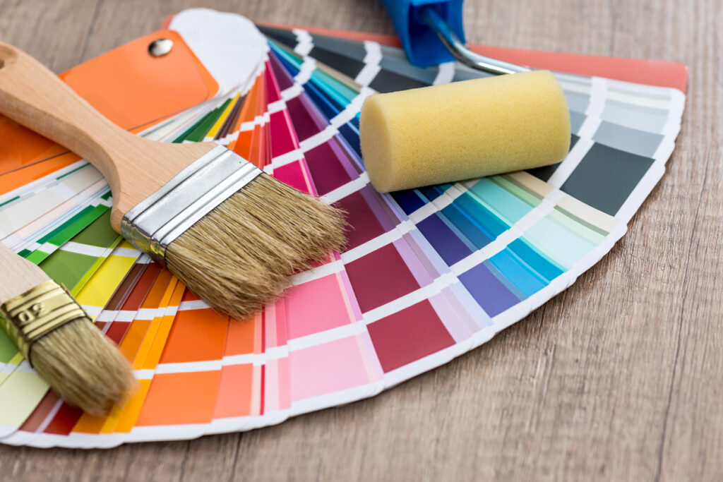 Paint brushes on colour swatch, wooden table background paint colors for home office